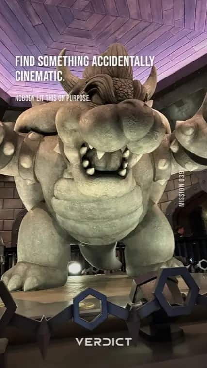 Verdict mission 39, "Find something accidentally cinematic.", answered with a giant Bowser statue lit purple at night.